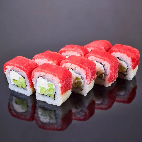 Filadelfia arrotolare sushi con tonno, cetriolo e crema di formaggio su sfondo nero per il menu. Cibo giapponese — Foto Stock