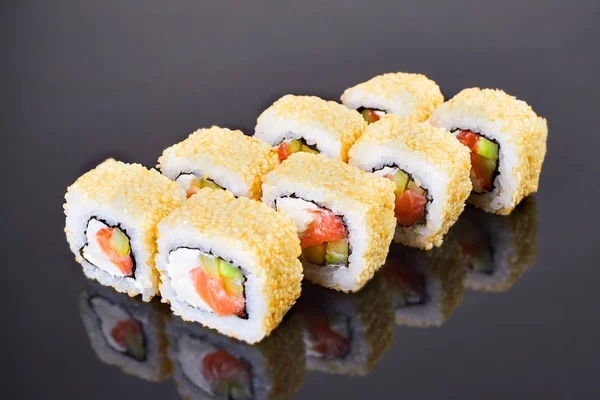 California roll sushi con sésamo, salmón, aguacate y queso crema sobre fondo negro para el menú. Comida japonesa — Foto de Stock