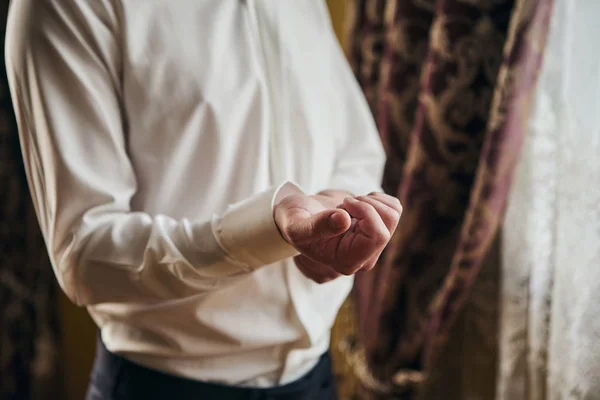 Hombre de negocios viste camisa blanca, manos masculinas primer plano, novio preparándose en la mañana antes de la ceremonia de boda — Foto de Stock