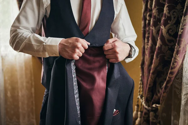 Empresario lleva una chaqueta, manos masculinas primer plano, novio preparándose en la mañana antes de la ceremonia de boda — Foto de Stock