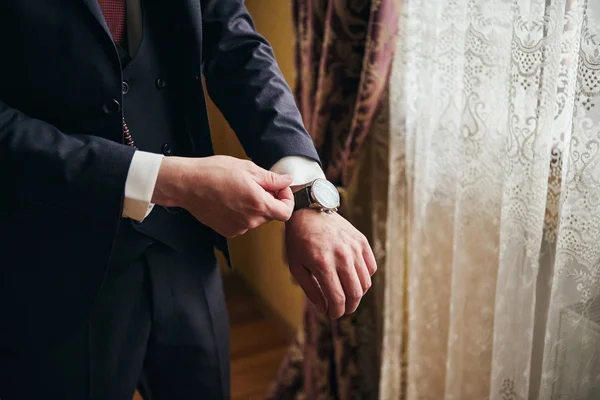 Empresario lleva una chaqueta, manos masculinas primer plano, novio consiguiendo readBusinessman lleva una chaqueta, manos masculinas primer plano, novio preparándose en la mañana antes de la ceremonia de boda — Foto de Stock