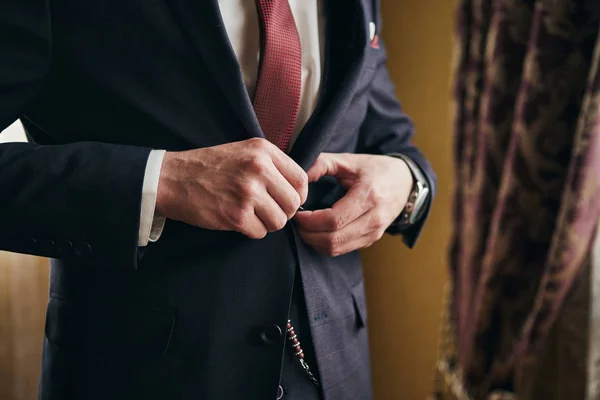 Uomo d'affari indossa una giacca, mani maschili primo piano, sposo si prepara al mattino prima della cerimonia di matrimonio — Foto Stock