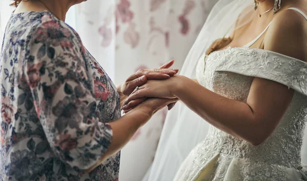 Noiva no dia do casamento segurando as mãos de sua mãe. Conceito de relação entre mães e filhas — Fotografia de Stock