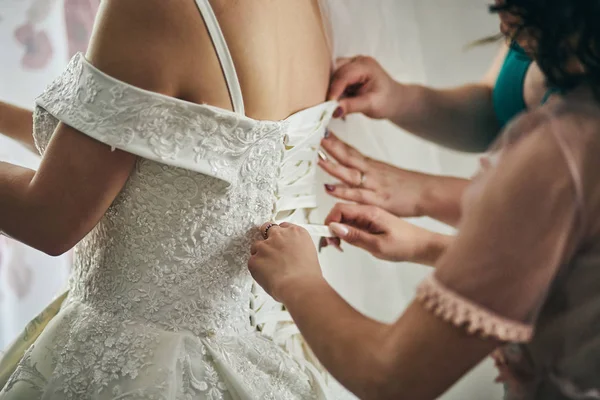 Manhã da noiva quando ela usa um vestido bonito, mulher se preparando antes da cerimônia de casamento — Fotografia de Stock