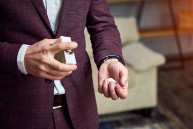 Yakışıklı olan parfüm, kolonya, kullanarak takım elbiseli şık adam seçme damat düğün töreni önce sabah hazırlanıyor