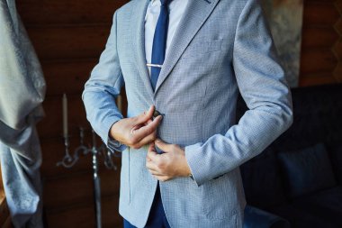 İş adamı ceket giyiyor, erkek eli kapalı, damat düğün töreninden önce hazırlanıyor.