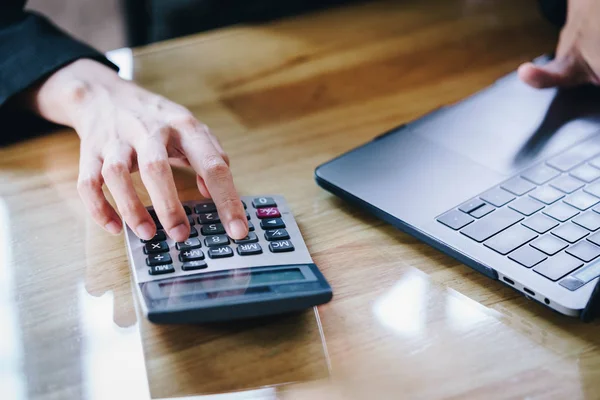Kadın girişimci finans hesaplamak için bir hesap makinesi kullanarak gider evde office.