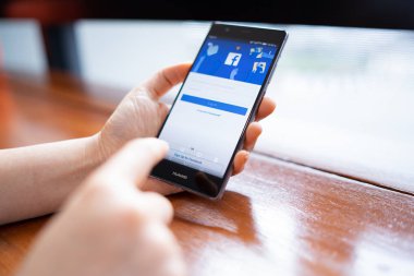 Chiang Mai, Tayland - Şubat 18,2019: facebook app üstünde belgili tanımlık perde ile Huawei tutan kadın. Facebook ücretsiz bir popüler sosyal medya paylaşım ve ağ bilgi için kullanılır.