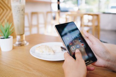 Chiang Mai, Tayland - Ocak 19,2019: kutsal kişilerin resmi üstünde belgili tanımlık perde sosyal medya ile Huawei tutan kadın. Sosyal medya türlerine araçlardır. Smartphone bir yaşam tarzı. Başlangıç sosyal medya uygulaması.