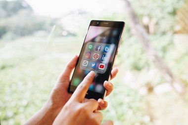 Chiang Mai, Tayland - Ocak 19,2019: kutsal kişilerin resmi üstünde belgili tanımlık perde sosyal medya ile Huawei tutan kadın. Sosyal medya türlerine araçlardır. Smartphone bir yaşam tarzı. Başlangıç sosyal medya uygulaması.