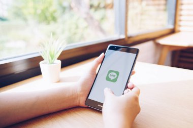 CHIANG MAI, THAILAND - 19 Ocak 2019: HUAWEI 'yi ekrana bağlayan kadın. LINE ücretsiz sesli arama yapmanızı ve ücretsiz mesaj göndermenizi sağlayan yeni bir iletişim uygulaması.