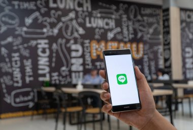 Chiang Mai, Tayland - Ocak 06,2019: adam çizgi apps üstünde perde ile Huawei tutarak. Ücretsiz sesli arama yapmak ve ücretsiz mesaj göndermek olanak sağlayan yeni bir iletişim app çizgidir.