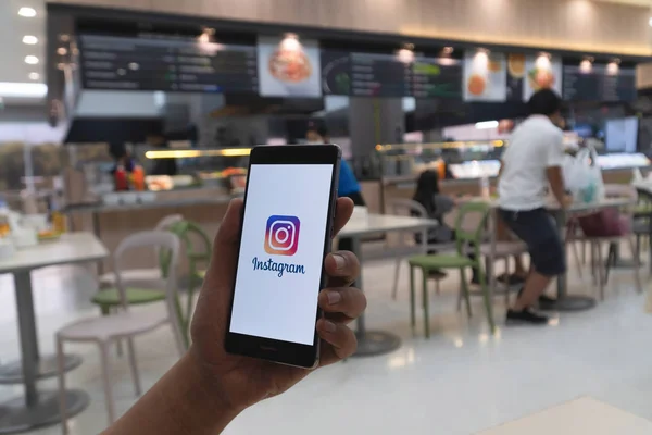 CHIANG MAI, TAILANDIA - ENERO. 06,2019: Hombre sosteniendo HUAWEI con aplicación de Instagram en la pantalla. Instagram es un popular servicio de redes sociales en línea . — Foto de Stock