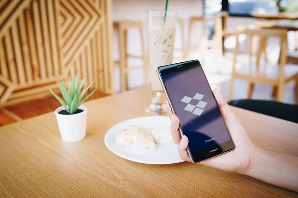 CHIANG MAI, TAILANDIA - ENERO. 19,2019: Mujer sosteniendo HUAWEI con Dropbox en pantalla. Dropbox es un servicio que te permite acceder a imágenes, documentos y vídeos en línea desde cualquier lugar . — Foto de Stock