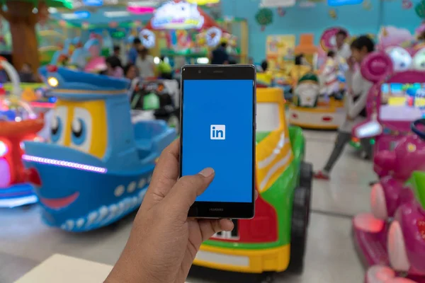 CHIANG MAI, THAILAND - JAN. 06,2019: Homem segurando celular HUAWEI com aplicativo Linkedin na tela. Linkedin é um serviço de redes sociais orientado para as empresas e o emprego . — Fotografia de Stock