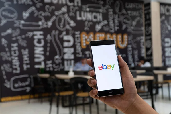 CHIANG MAI, TAILANDIA - ENERO. 06,2019: Hombre sosteniendo HUAWEI con aplicaciones de eBay en la pantalla. eBay es una de las maneras más populares de comprar y vender mercancías y servicios en el Internet . — Foto de Stock