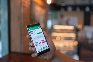 Chiang Mai, Tayland - 09 Haziran 2018: Ekranda Linkedin uygulaması ile Huawei cep telefonu tutan adam. Linkedin bir iş ve istihdam odaklı sosyal ağ hizmetidir.