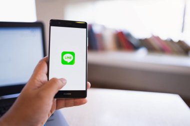 Chiang Mai, Tayland - Haziran 03,2018: adam çizgi apps üstünde perde ile Huawei tutarak. Ücretsiz sesli arama yapmak ve ücretsiz mesaj göndermek olanak sağlayan yeni bir iletişim app çizgidir.