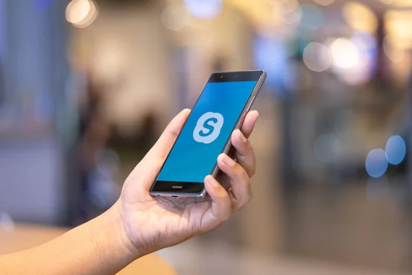 CHIANG MAI, TAILANDIA - 28 de octubre de 2018: Hombre sosteniendo HUAWEI con aplicaciones de Skype. Skype es parte de Microsoft, puede hacer video, llamadas de audio, mensajes de chat y hacer mucho más usando Skype . — Foto de Stock