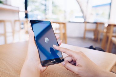 Chiang Mai, Tayland - Ocak 19,2019: Paypal apps üstünde belgili tanımlık perde ile Huawei tutan kadın. PayPal bir online elektronik ödeme sistemidir.