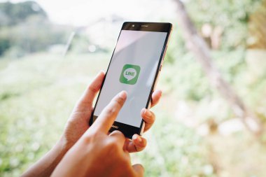 CHIANG MAI, THAILAND - 19 Ocak 2019: HUAWEI 'yi ekrana bağlayan kadın. LINE ücretsiz sesli arama yapmanızı ve ücretsiz mesaj göndermenizi sağlayan yeni bir iletişim uygulaması.