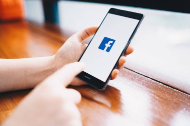 Chiang Mai, Tayland - Şubat 18,2019: facebook app üstünde belgili tanımlık perde ile Huawei tutan kadın. Facebook ücretsiz bir popüler sosyal medya paylaşım ve ağ bilgi için kullanılır.