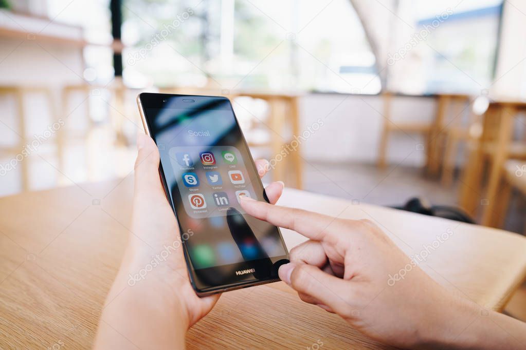 CHIANG MAI, THAILAND - JAN. 19,2019: Woman holding HUAWEI with icons of social media on the screen. Social media are most popular tool. Smartphone lifestyle. Starting social media app.