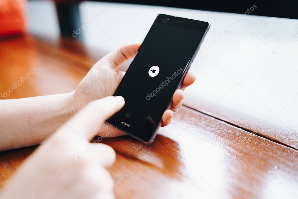 CHIANG MAI, THAILAND - FEB. 16,2019: Woman holding HUAWEI with Uber apps. Uber is smartphone app transportation network for searching, calling and paying a taxi or private drivers.