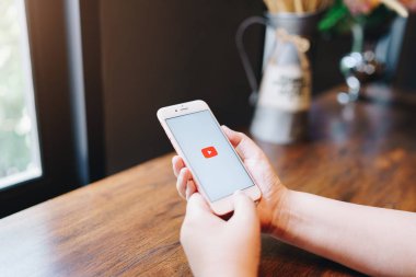 CHIANG MAI, THAILAND - 08: 2019: Elma iPhone 6S Rose Gold 'u elinde tutan kadın Youtube uygulamalarıyla ekranda. YouTube popüler bir çevrimiçi video paylaşım sitesidir..