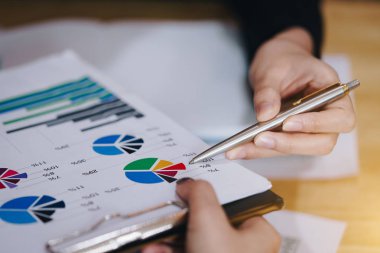 İş insanlar işaretleme kalemi Toplantı salonunun içinde projeyi tartışmak üzere mali belge üzerinde.