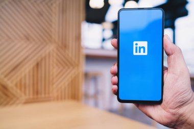 Chiang Mai, Tayland - Mar. 23,2019: Ekranda Linkedin uygulaması ile Xiaomi Mi Mix 3 cep telefonu tutan adam. Linkedin bir iş ve istihdam odaklı sosyal ağ hizmetidir.