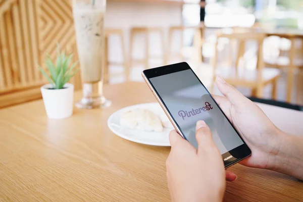 CHIANG MAI, TAILANDIA - ENERO. 19,2019: Mujer sosteniendo el teléfono móvil HUAWEI con aplicaciones de Pinterest en pantalla. Pinterest es una pizarra en línea que permite a la gente fijar sus cosas interesantes . — Foto de Stock