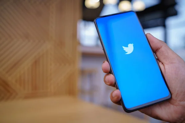 ЧЬЯН-ИЯ, ТАИЛАНД - Март. 23.2019: Man holding Xiaomi Mi Mix 3 with Twitter app on the screen.Twitter is an online news and social networking service where users post and interact with messages . — стоковое фото