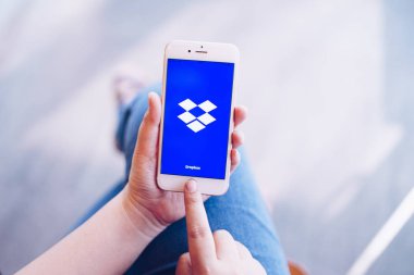 Chiang Mai, Tayland-Apr. 08, 2019: Apple iPhone 6s tutan kadın ekranda Dropbox ile altın gül. Dropbox her yerden görüntü, belge ve video çevrimiçi erişim sağlayan bir hizmettir.