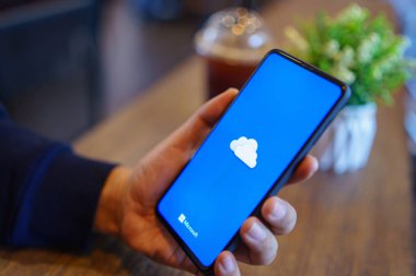 CHIANG MAI, THAILAND - Mar. 24,2019: Xiaomi Mi Mix 3 'ü elinde tutan adam ekranda OneDrive ile. Microsoft OneDrive, kullanıcıların dosyaları senkronize etmesini sağlayan bir dosya sunucu hizmetidir.