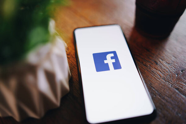 CHIANG MAI, THAILAND - Mar. 24,2019: Man holding Xiaomi Mi Mix3 with facebook app on the screen. Facebook is a popular free social media are used for information sharing and networking.