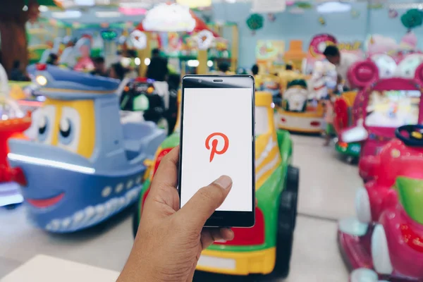 CHIANG MAI, TAILANDIA - ENERO. 06,2019: Hombre sosteniendo el teléfono móvil HUAWEI con aplicaciones de Pinterest de inicio de sesión en la pantalla. Pinterest es una pizarra en línea que permite a la gente fijar sus cosas interesantes . — Foto de Stock