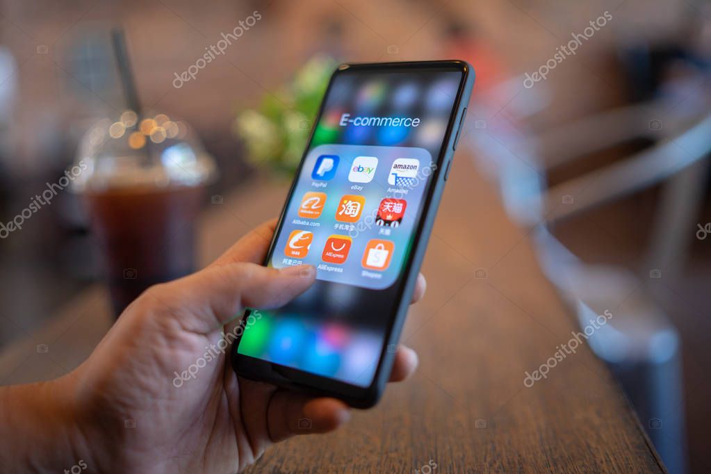 CHIANG MAI, THAILAND - Mar. 24,2019: Man holding Xiaomi Mi Mix 3 with icons of E-commerce and online shopping on screen.smartphone lifestyle,e-commerce app concept.