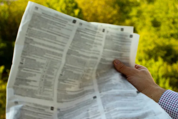 Morning newspaper in a man\'s hand. A man reading a newspaper