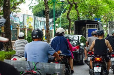 Hanoi 'deki sokak sahnesinde yerel dükkanlar, insanlar, scooterlar ve araçlar var. Hanoi, Vietnam, Temmuz 2025