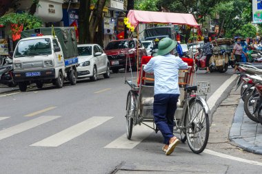 Geleneksel bisiklet (risho) Hanoi, Vietnam sokaklarında sürüşü. Bisiklet, Fransız sömürgesi sırasında Vietnam 'da ortaya çıkan üç tekerlekli bir bisiklet taksisidir. Hanoi, Vietnam, Temmuz 2025