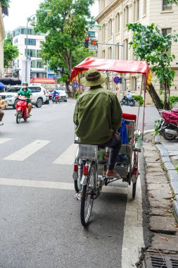 Geleneksel bisiklet (risho) Hanoi, Vietnam sokaklarında sürüşü. Bisiklet, Fransız sömürgesi sırasında Vietnam 'da ortaya çıkan üç tekerlekli bir bisiklet taksisidir. Hanoi, Vietnam, Temmuz 2025