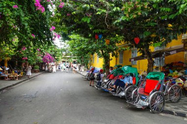 Bisiklet sürücüleri dinlenir ve bir sonraki yolculuğu bekler. Hoi An, Vietnam, Temmuz 2025