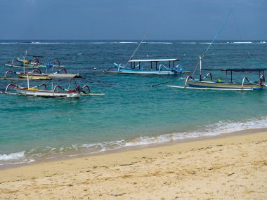 Gili Adaları, Gili Trawangan, Gili Meno, Gile Air 'deki gelgit sırasında geleneksel stil kano balıkçı tekneleri Jukung. Teknelere iki bambu dengeleyici takıldı, her iki tarafa da, alabora olma ihtimalini azaltmak için. Jukung olarak biliniyor. Bali, 