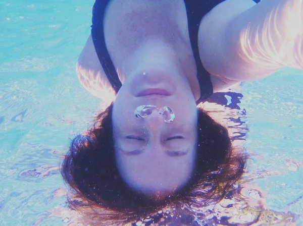 Mulher de cara para baixo mergulho em uma piscina — Fotografia de Stock