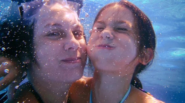 Mãe e filha mergulhando em uma piscina — Fotografia de Stock