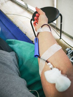 kişi kan bağış için sedye oturur