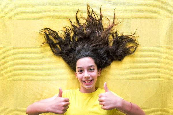 Gadis bahagia membuat wajah di latar belakang kuning — Stok Foto