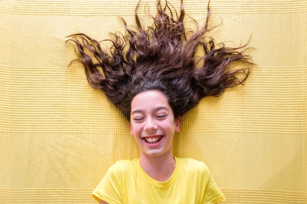 Chica feliz haciendo caras sobre fondo amarillo — Foto de Stock