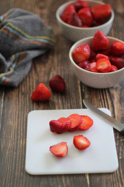 Fresas en una tabla de cortar blanca sobre un fondo de madera —  Fotos de Stock